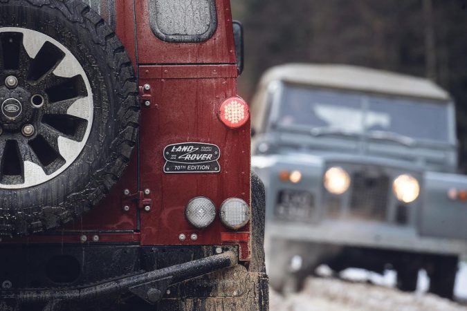 Land Rover Defender Works V8 - rear badge in red and background car in blue