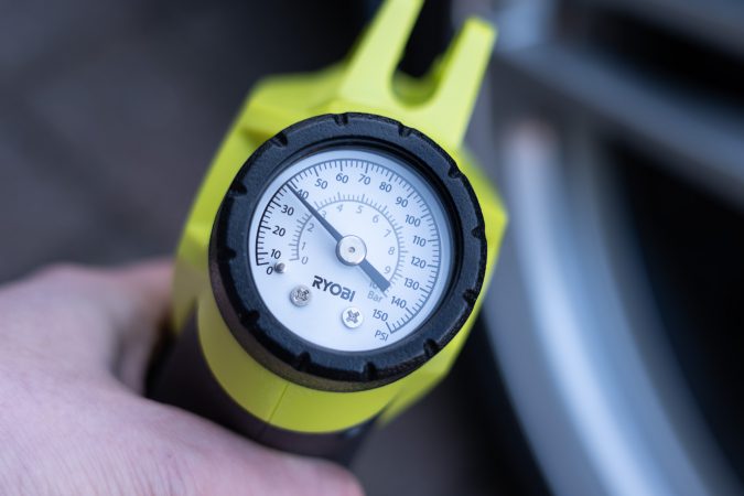 Using a portable cordless tire inflator to monitor and top-up the tire pressure psi gauge